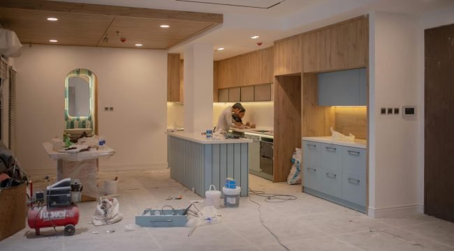 pexels photo 15124970 15124970 A modern kitchen undergoing renovation, featuring a worker, tools, and materials.